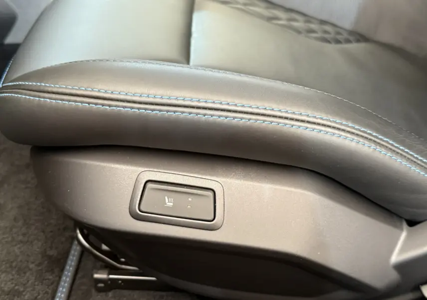 Gros plan sur le bouton de chauffage intégré au siège en cuir bleu de l'Alpine A110 Légende 2019.