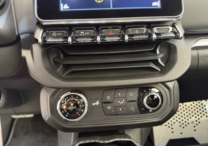 Vue rapprochée du tableau de bord de l'Alpine A110 Légende 2019, mettant en valeur la console de climatisation noire avec commandes circulaires.