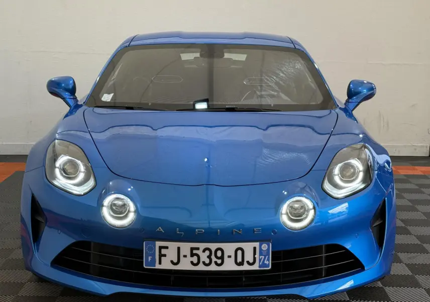 Vue avant d'une Alpine A110 Legende 2019 bleu électrique avec ses phares LED ronds distinctifs allumés.