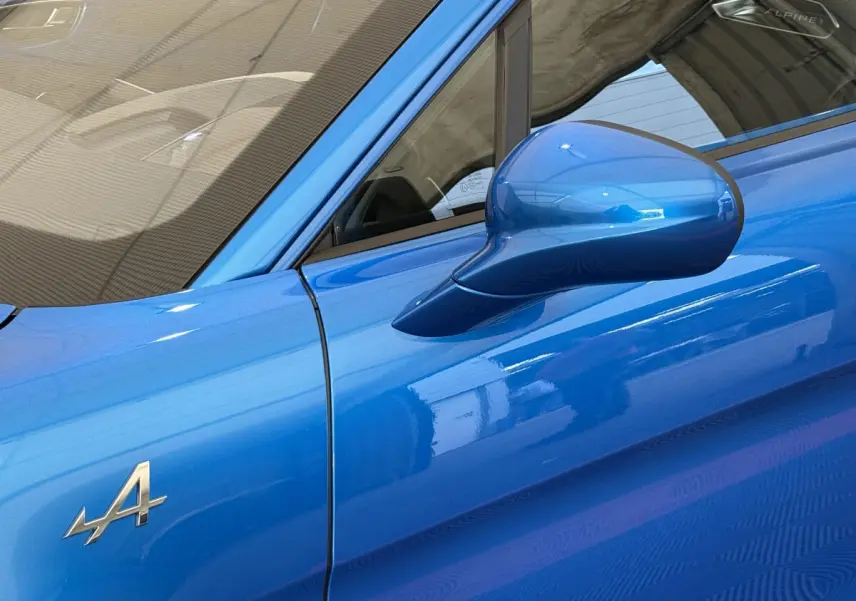 Détail du rétroviseur côté gauche et logo Alpine sur la portière d'une A110 Legende bleu 2019.