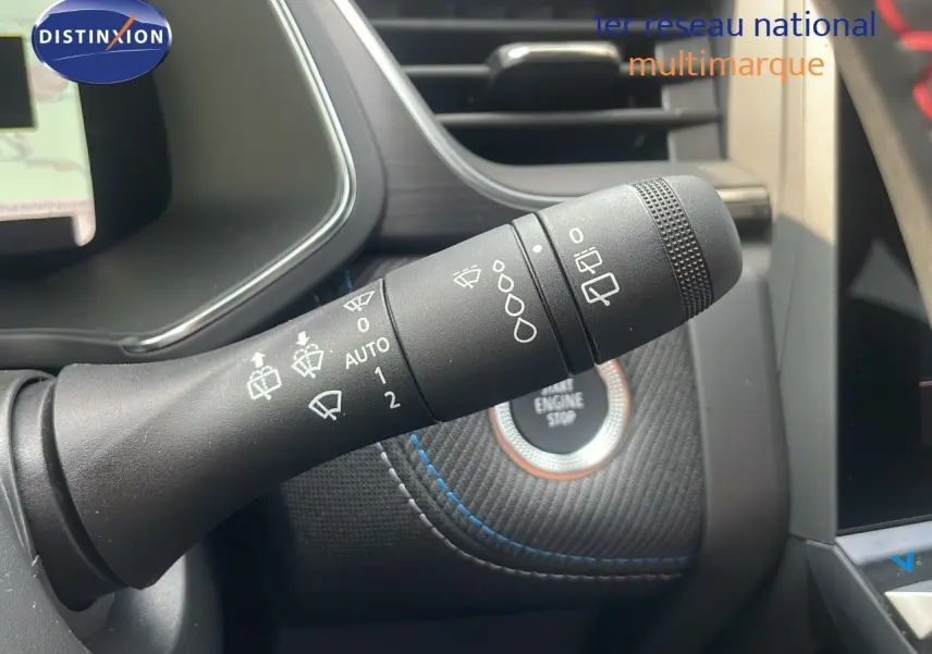 Gros plan sur la commande d'essuie-glace du Renault Captur E-Tech gris Cassiopée, avec bouton start/stop en arrière-plan.