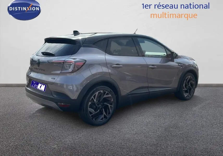 Vue 3/4 arrière droite d’un Renault Captur gris cassiopée métal avec toit noir et jantes noires distinctives.