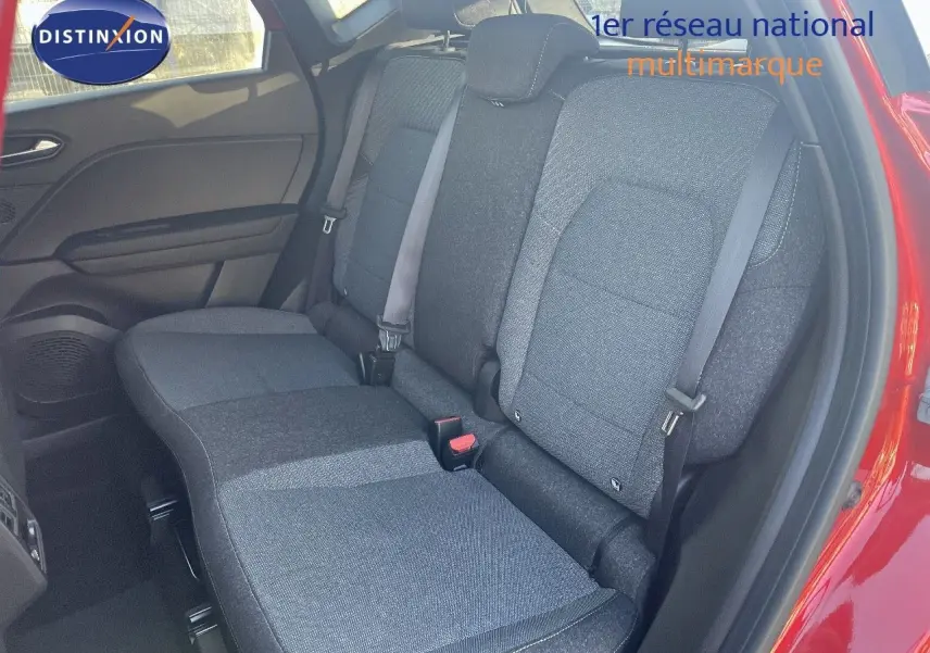 Vue intérieure sur les sièges arrière gris foncé du Renault Captur E-Tech Hybrid 2025, porte arrière rouge passion ouverte.