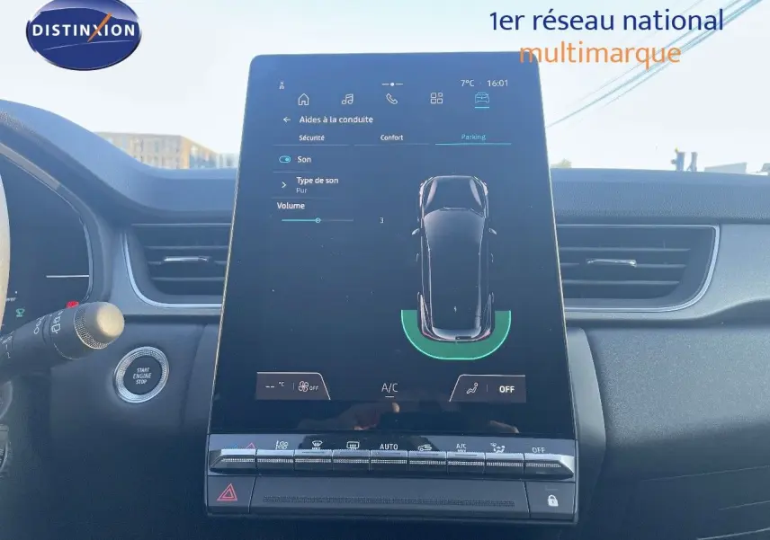 Vue rapprochée de l’écran tactile central du Renault Captur E-Tech hybride, avec tableau de bord noir et commandes visibles.