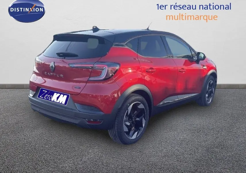 Vue 3/4 arrière droite d’un Renault Captur E-Tech hybride rouge passion avec toit noir et jantes noires.