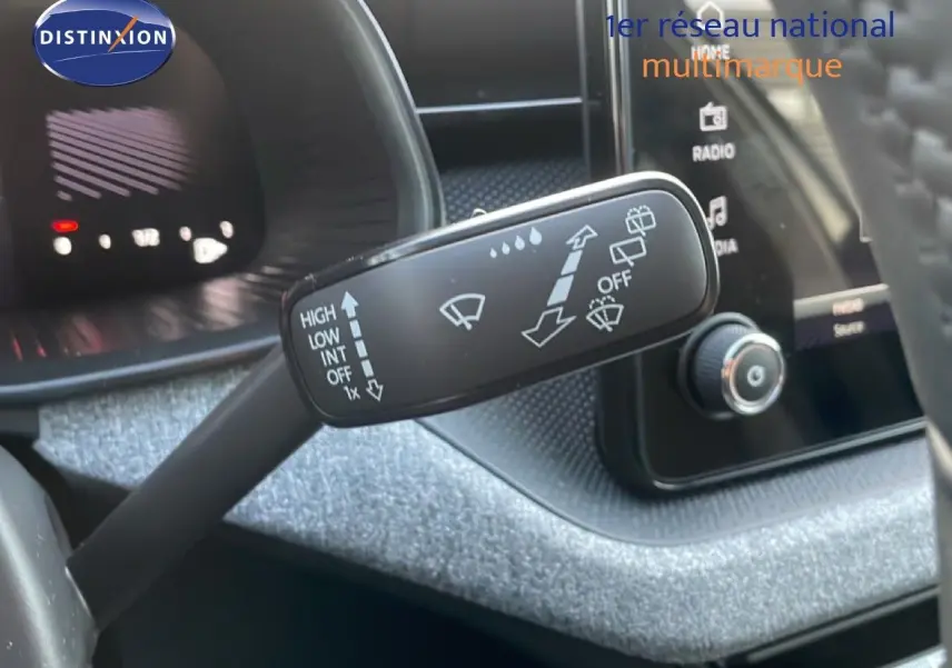 Gros plan sur la commande d’essuie-glace dans l’habitacle du Skoda Kamiq gris argent métal, avec tableau de bord et écran tactile en arrière-plan.