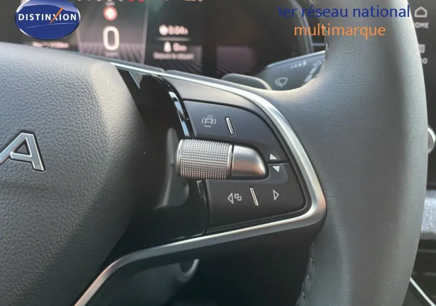 Gros plan sur la partie gauche du volant cuir noir du Skoda Kamiq gris argent, avec commandes intégrées et molette métallique.