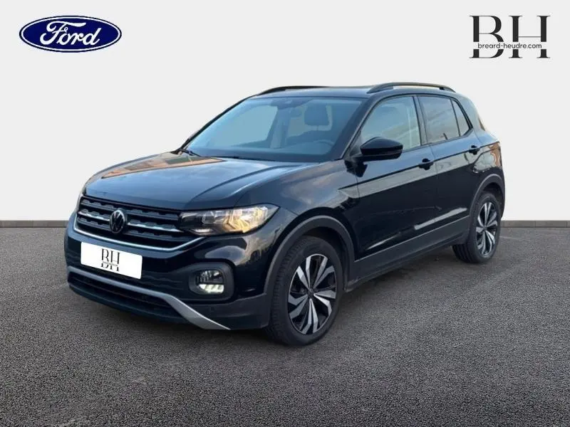 Volkswagen T-Cross noir intense nacré vu en 3/4 avant droit avec jantes alu bicolores et calandre chromée.