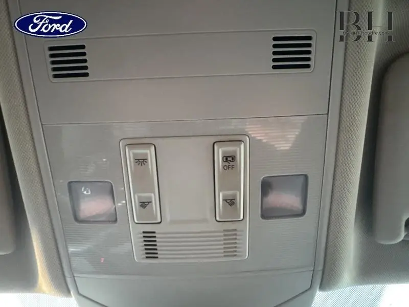 Jeu de commandes d'éclairage intérieur gris clair vu de dessous, sans lien visible avec un Volkswagen T-cross noir nacré.