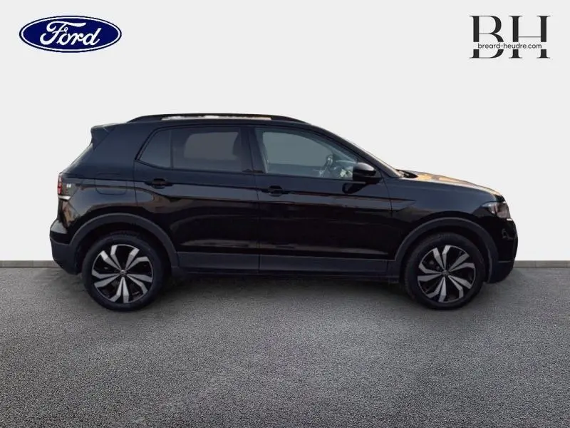 Profil côté gauche du Volkswagen T-Cross noir intense nacré avec jantes 17 pouces bicolores sur fond clair.