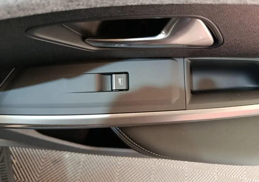 Détail de la commande de lève-vitre côté gauche dans l'intérieur noir du Peugeot 3008 1.2 Hybrid 145 GT 2025.