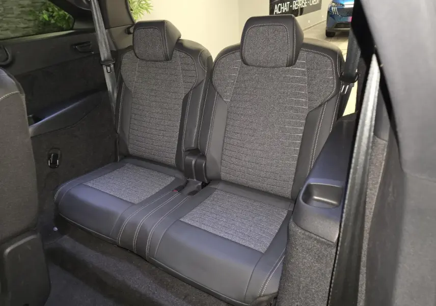 Vue intérieure rapprochée des deux sièges arrière en tissu gris et cuir noir du Peugeot 5008 blanc 2025.