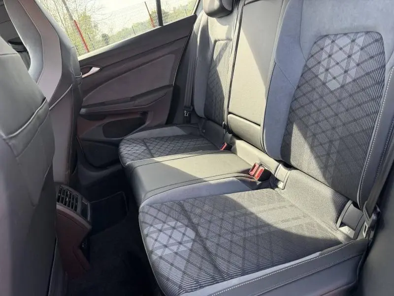 Vue intérieure du siège arrière côté droit de la Volkswagen Golf 1.5 eTSI R-Line 2024 avec sellerie tissu et cuir noir à motifs géométriques.