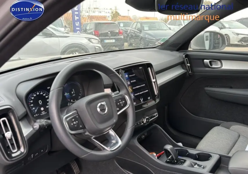 Intérieur du Volvo XC40 T4 hybride 2023, vue côté conducteur montrant tableau de bord et volant cuir noir.