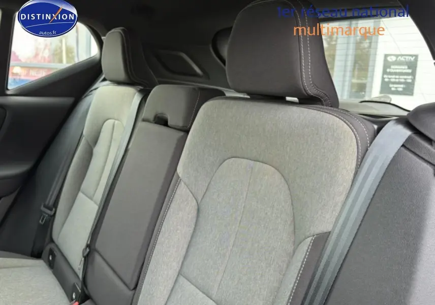 Vue intérieure sur la banquette arrière gris clair du Volvo XC40 T4 Recharge 2023 avec accoudoir central relevé.