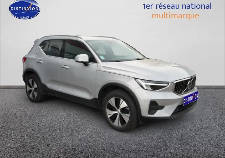 Vue 3/4 avant droit d'un Volvo XC40 T4 hybride gris avec jantes alu et calandre distinctive.