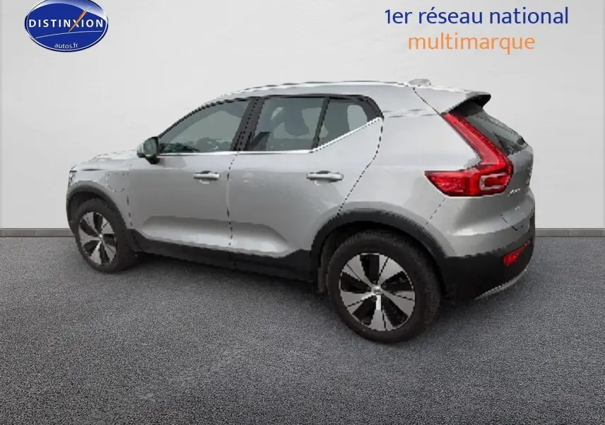 Vue de profil côté gauche d'un Volvo XC40 T4 hybride gris avec jantes alu et feux arrière en L distinctifs.