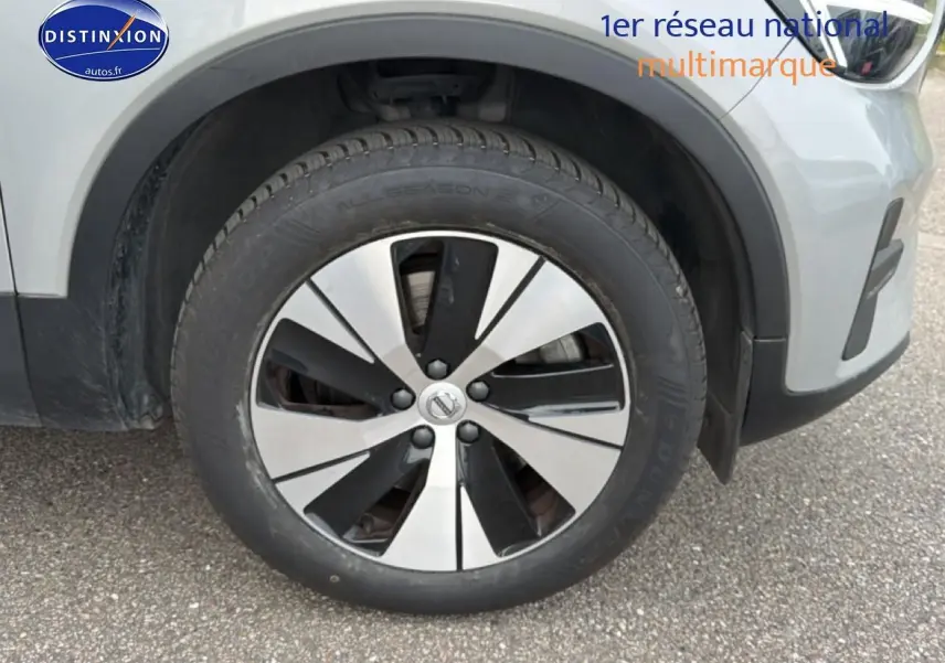 Gros plan sur la roue avant droite d’un Volvo XC40 gris 2023 avec jante alu bicolore et partie avant visible.