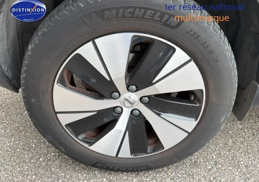 Gros plan sur la jante alu bicolore et le pneu Michelin du Volvo XC40 gris, côté avant droit.