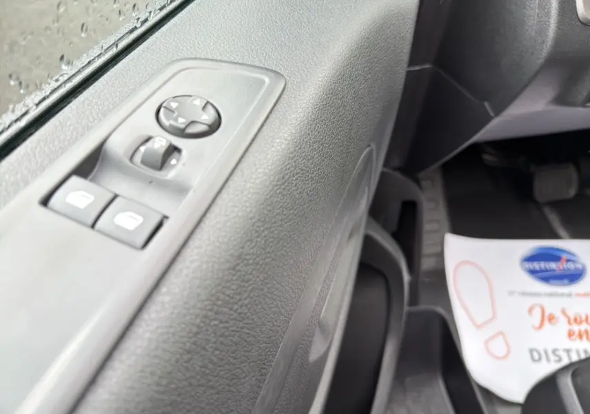 Gros plan sur la porte côté conducteur du Citroën Jumpy gris foncé, montrant les commandes des vitres électriques.