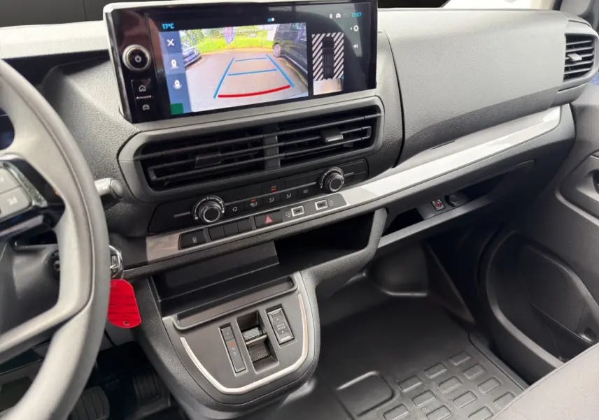 Vue intérieure du tableau de bord du Citroën Jumpy gris foncé, avec écran tactile affichant la caméra de recul.