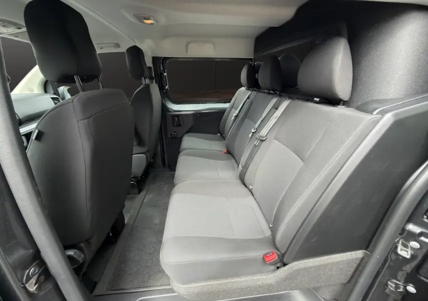 Vue intérieure côté droit sur la banquette arrière grise du Citroën Jumpy XL 2026 avec cloison vitrée fixe.