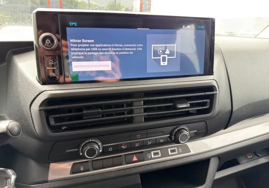 Vue rapprochée de la console centrale du Citroën Jumpy gris foncé, avec écran tactile et commandes de climatisation.