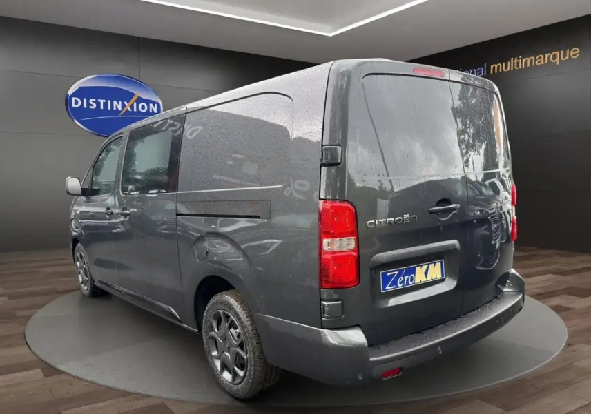 Vue 3/4 arrière droite d’un Citroën Jumpy XL gris foncé avec porte latérale coulissante et feux arrière rouges.
