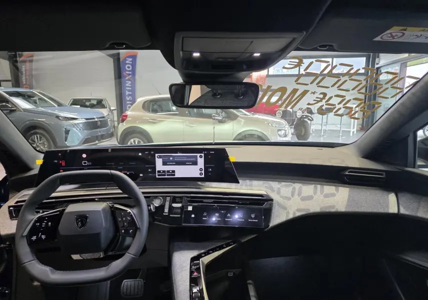 Vue intérieure avant du Peugeot 3008 bleu, tableau de bord avec écran panoramique et volant compact noir.