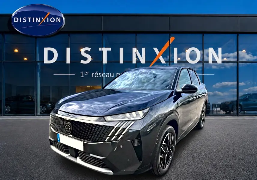 Peugeot 3008 gris titane en 3/4 avant droit, avec calandre distinctive et jantes alu noires devant showroom Distinxion.