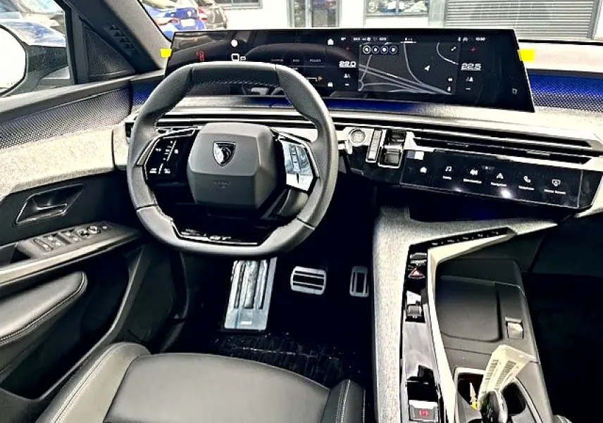 Vue intérieure avant du Peugeot 3008 1.2 hybrid gris titane, avec tableau de bord numérique et volant multifonction cuir.