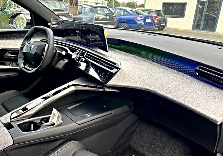 Vue intérieure côté conducteur du Peugeot 3008 gris titane 2025, avec tableau de bord moderne et écran tactile incurvé.