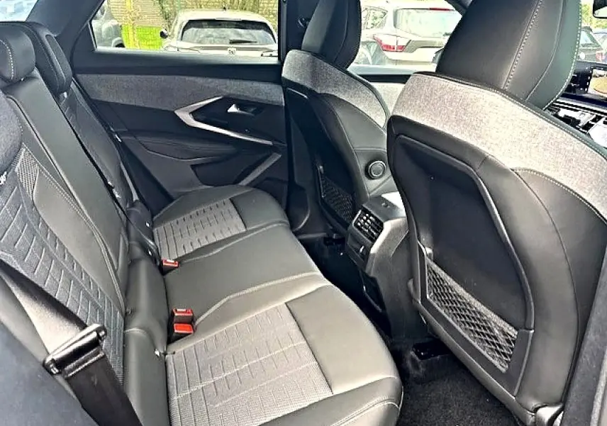 Vue intérieure arrière côté droit du Peugeot 3008 gris titane, montrant les sièges et les rangements au dos des sièges avant.