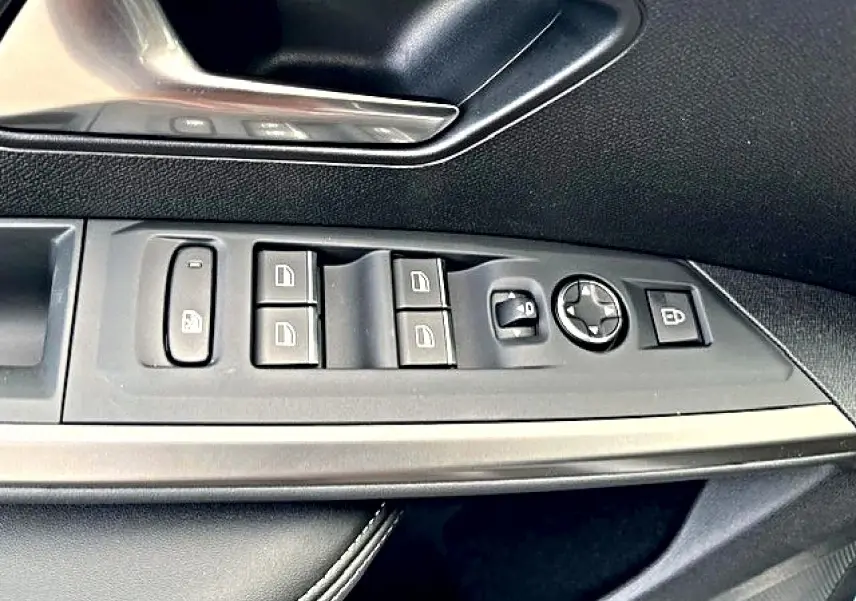 Vue rapprochée du panneau de commandes des vitres côté conducteur du Peugeot 3008 gris titane avec boutons de réglage et verrouillage.