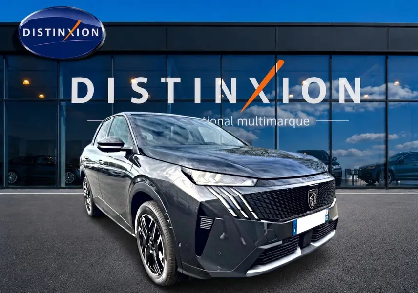 Peugeot 3008 gris titane en 3/4 avant droit, avec calandre noire distinctive et jantes alu noires.