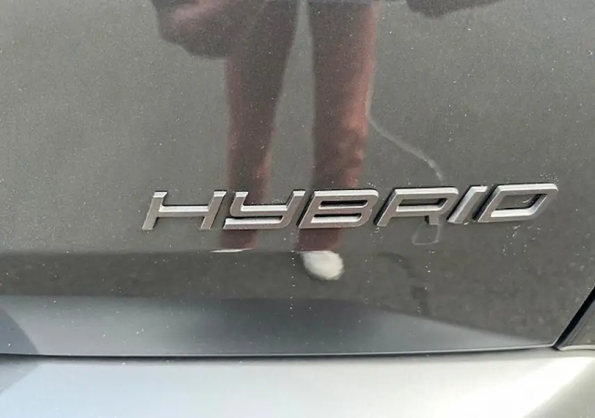 Gros plan sur l’inscription « Hybrid » sur la carrosserie gris titane d’un Peugeot 3008 2025.
