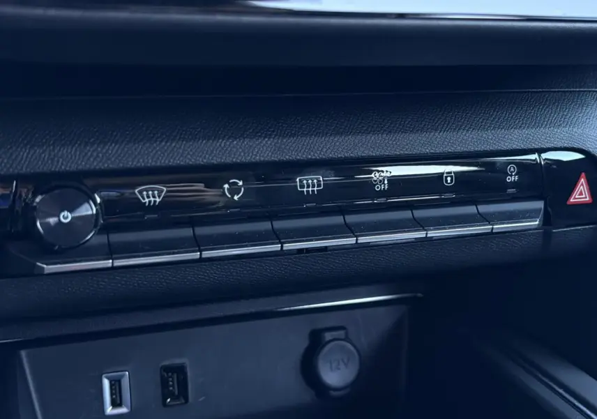 Détail de la console centrale du Citroën C5 Aircross Hybrid 2025, boutons de climatisation et prises USB visibles.