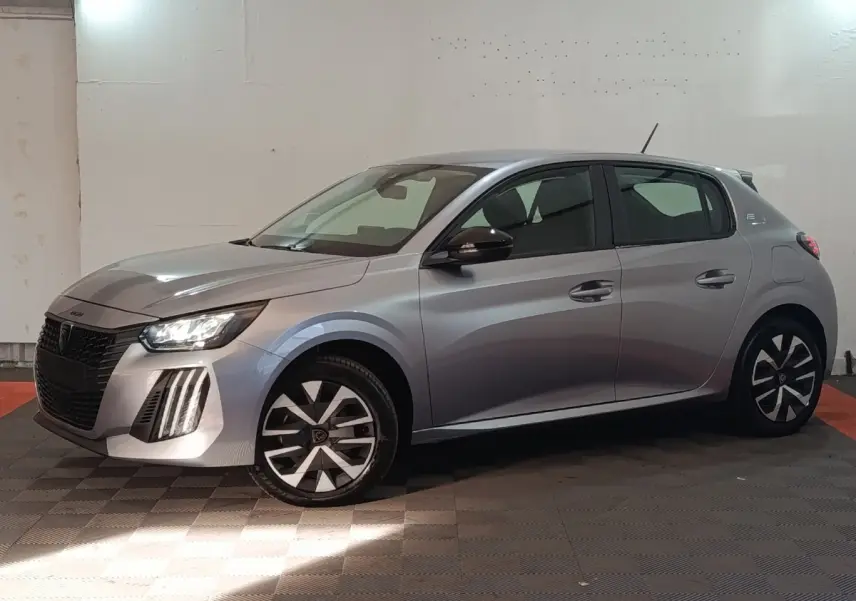 Peugeot 208 électrique gris clair vue de profil côté gauche, avec phares LED et jantes stylisées.