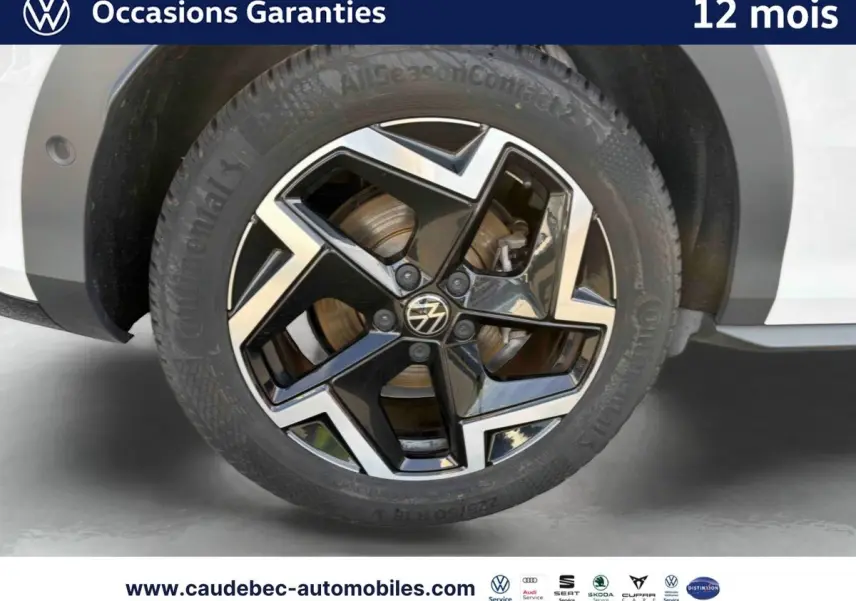 Gros plan sur la jante alliage Coventry noire et brillante du côté arrière droit d’un Volkswagen T-Roc blanc 2025.