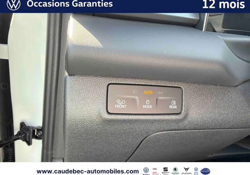 Détail du tableau de bord côté passager du Volkswagen T-Roc blanc 2025 avec commandes d’éclairage automatiques.
