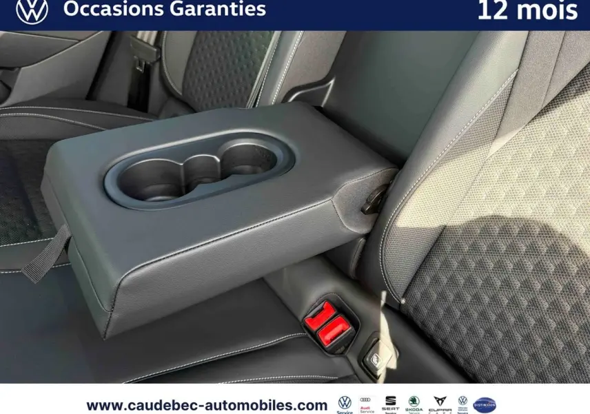 Gros plan sur l'accoudoir central arrière avec porte-gobelets et sellerie noire du Volkswagen T-Roc 2025.