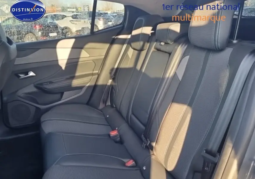 Vue latérale droite de la banquette arrière en tissu gris de la Peugeot 408 Hybrid 145 allure 2025 avec ceintures et appuie-têtes.
