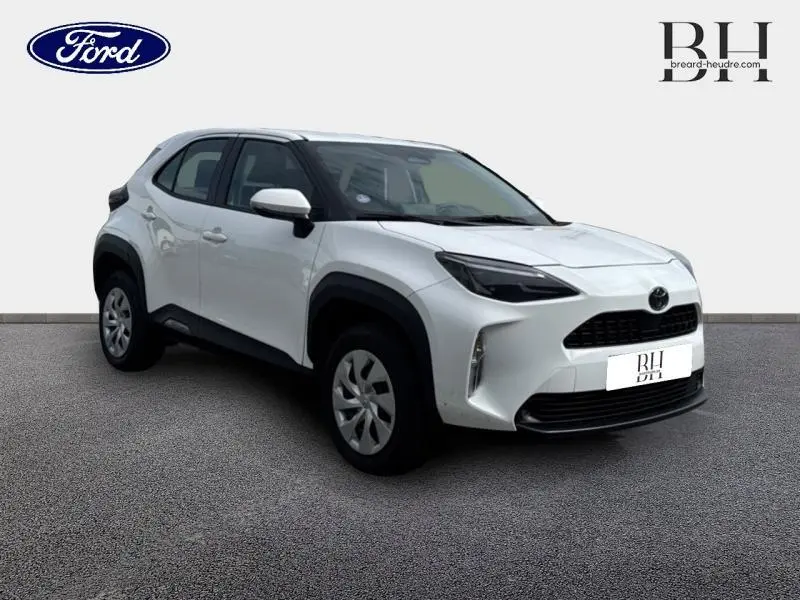 Toyota Yaris Cross blanc vue 3/4 avant droit avec détails noirs contrastants sur les passages de roues et calandre.