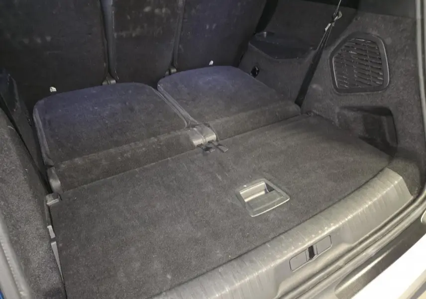 Coffre du Peugeot 5008 2025 avec banquette arrière rabattue, revêtement tissu noir et espace de chargement plat.