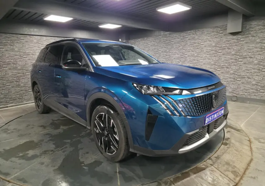 Peugeot 5008 bleu métallisé en 3/4 avant droit, avec calandre noire et jantes alliage 19'' diamantées.