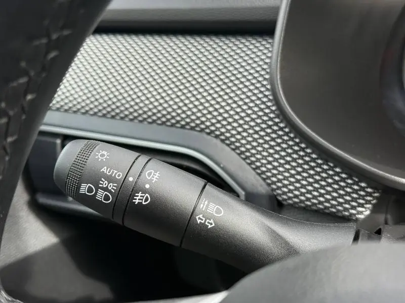 Gros plan sur la commande des feux du tableau de bord du Dacia Jogger 2025, intérieur avec finition gris schiste métallisé.