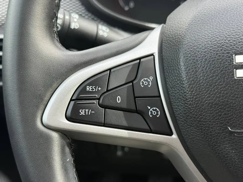 Gros plan sur les commandes de régulateur de vitesse au volant du Dacia Jogger 2025, intérieur noir et gris.