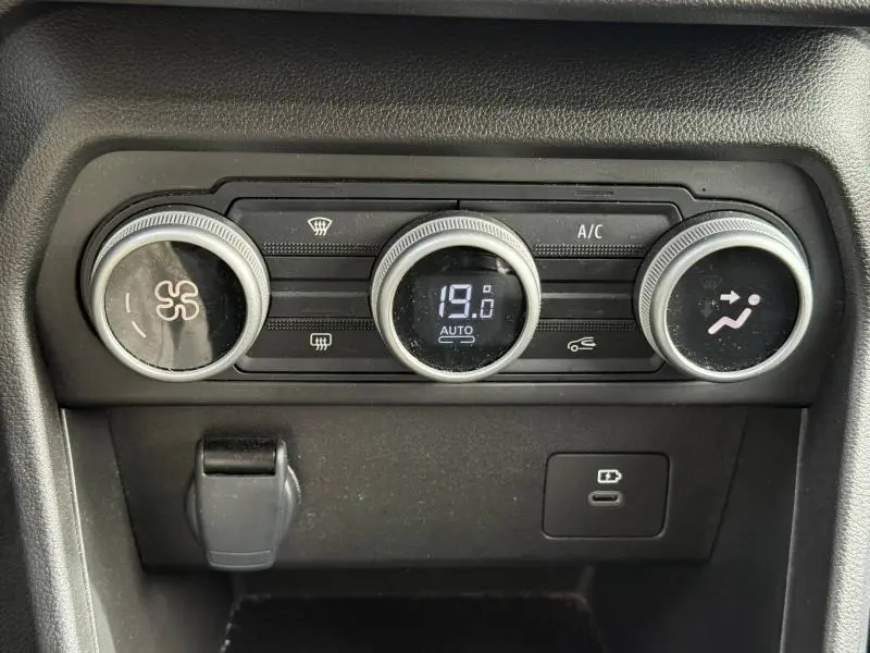 Tableau de commande de climatisation du Dacia Jogger 2025 avec réglage digital à 19°C et boutons ronds argentés.