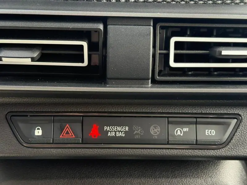 Gros plan sur la console centrale du Dacia Jogger 2025, montrant les voyants et commandes sous les aérateurs noirs.