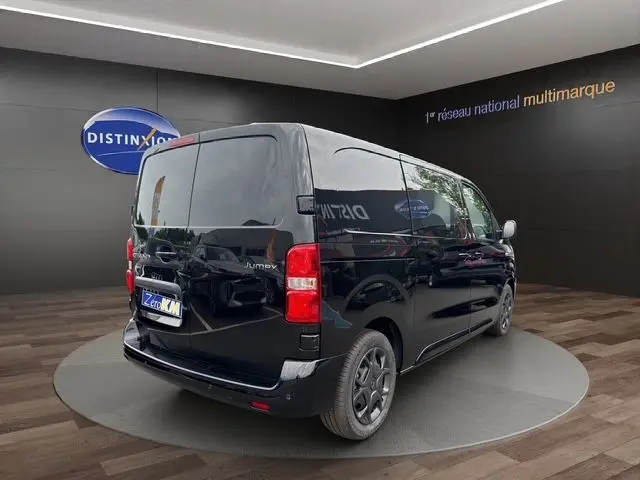 Vue 3/4 arrière droite du Citroën Jumpy noir 2025 avec vitres teintées et feux arrière rouges visibles.